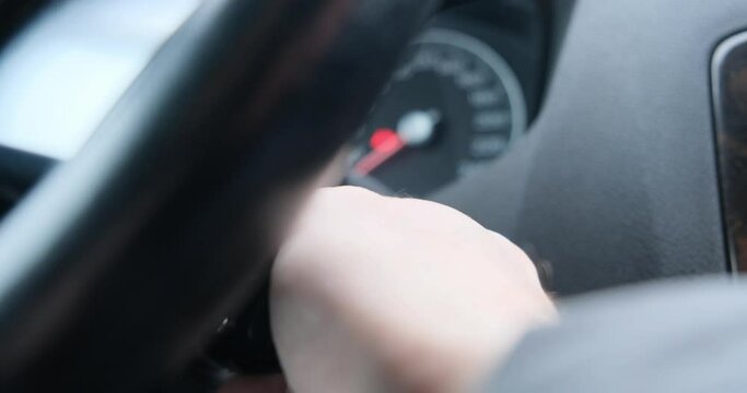 The man starts the car with the ignition key. Starting the engine. The concept of buying and selling a car, traffic rules, car service, driving school, auto instructor