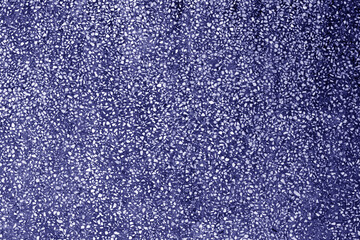 Wall made of small crushed stones and concrete in blue tone.