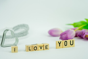 Walentynkowa karta z napisem kocham cię z różowymi tulipanami sercami w kolorze szarym i wstążką.