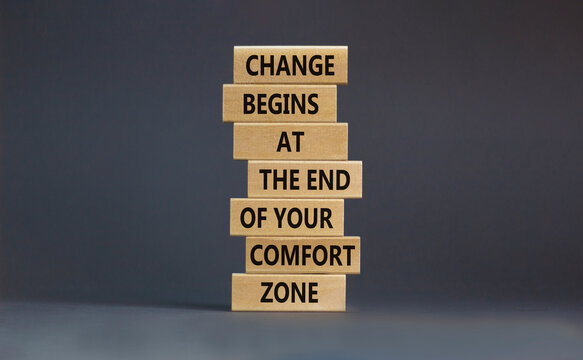 Out from comfort zone symbol. Wooden blocks with words Change begins at the end of your comfort zone. Beautiful grey table, grey background, copy space. Business, out from comfort zone concept.