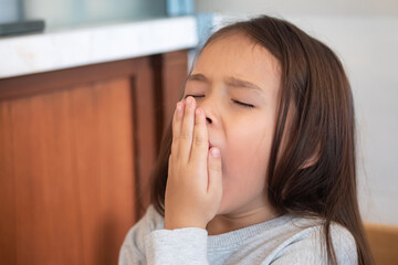 Tired and sleepy young little girl yawing