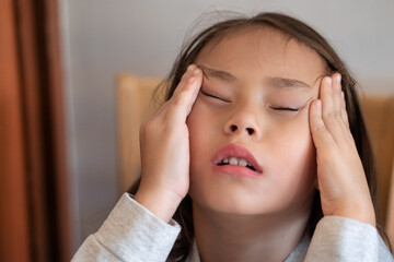 Sick young little girl having headache or fever