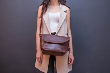 Woman holding brown leather bag