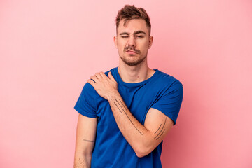 Young caucasian man isolated on pink background having a shoulder pain.