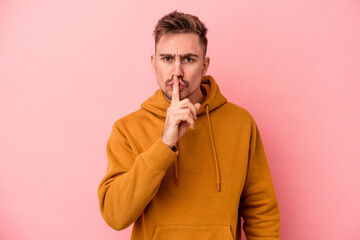 Young caucasian man isolated on pink background keeping a secret or asking for silence.