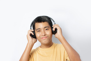 Happy young man in headphones listening to music isolated on white background.