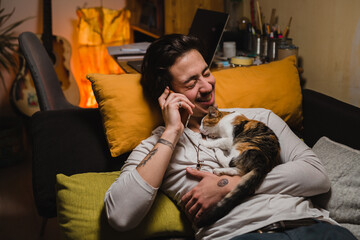 young man relaxing on sofa at his home and using mobile phone