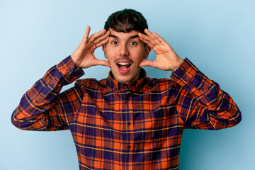 Young mixed race man isolated on blue background receiving a pleasant surprise, excited and raising hands.