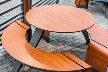 Empty brown round table and benches stands near fast food restaurant. Outdoor cafe. Urban. No...