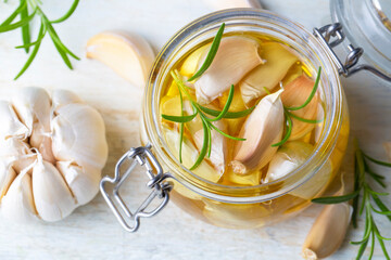 Fresh garlic and garlic oil on the wooden background