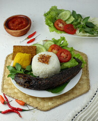 Fried catfish with sambal rice and pepes complete with vegetables and chili