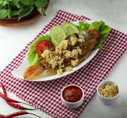 Crispy fried fish served with rice, vegetables and chili