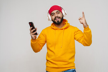 Bearded south asian man dancing while listening music with headphones