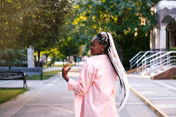 Fototapeta premium Beautiful black woman with braided hair posing at street.