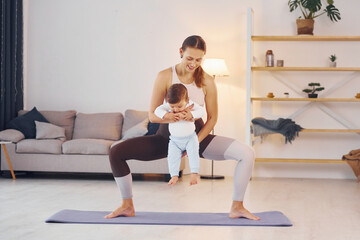 Fototapeta na wymiar Teaching fitness. Mother with her little daughter is at home together