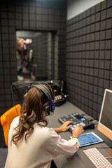 Obraz na płótnie Canvas Professional female sound engineer monitoring the audio quality