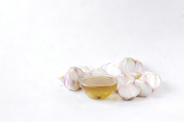 red inion oil in a container on table on white background 