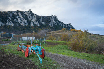 Bright mower in a field with Monte Titano and all three San Marino towers in background