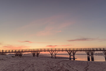 Fototapeta na wymiar wooden bridge over the sea at sunset