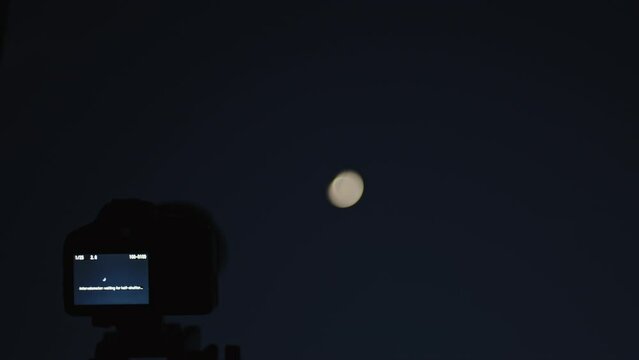 Close up of a mirrorless camera shooting a timelapse at moon