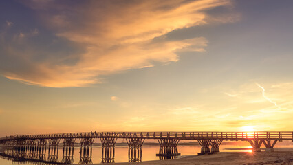 Naklejka na ściany i meble wooden bridge over the sea at sunset