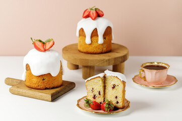 Easter cakes with white meringue and strawberries on wooden boards