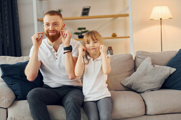 Learning to talk some words. Father with his little daughter is at home together