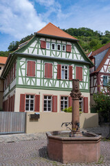 A beautiful old half-timbered house with an old fountain in front of it in Heppenheim/Germany in the Odenwald 