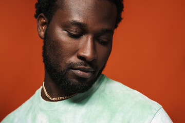 Obraz premium Young black man with beard posing and looking downward