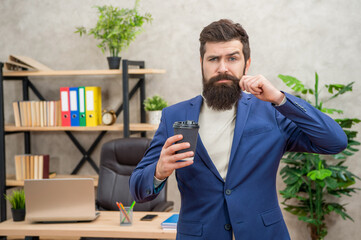 bearded mature entrepreneur in jacket having coffee break in paper cup, coffee break