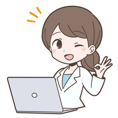 白衣姿でPCの前でOKサインを出す若い女性