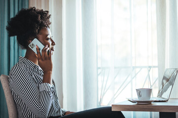 Outraged attractive employee talking on the phone, arguing with a client or customer, actively...