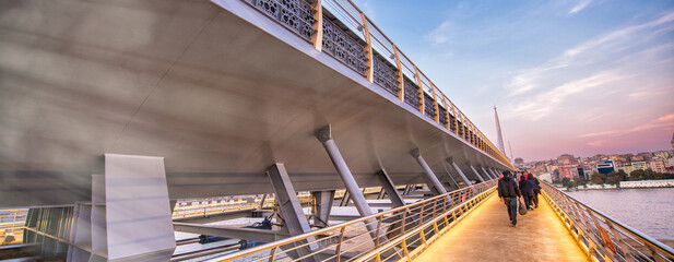ISTANBUL, TURKEY - OCTOBER 22, 2014: Tourists and locals at sunset along Golden Horn Metro Bridge...