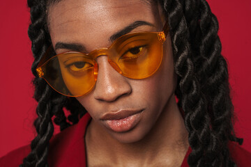 Black young woman wearing sunglasses posing and looking at camera