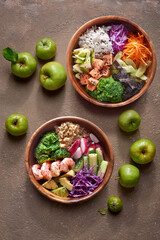 Bowls with shrimp and salmon on a dark background
