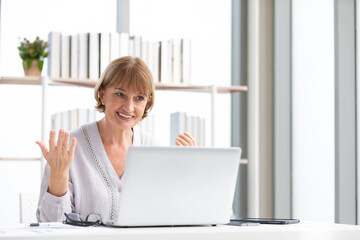 senior businesswoman video chat from laptop computer and talking to someone