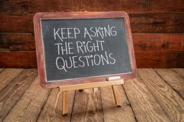keep asking the right questions inspirational reminder - white chalk handwriting on a slate blackboard, easel sign against rustic, weathered wood, education, business and science concept