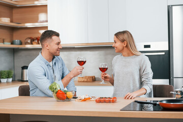 Cute people. Couple preparing food at home on the modern kitchen