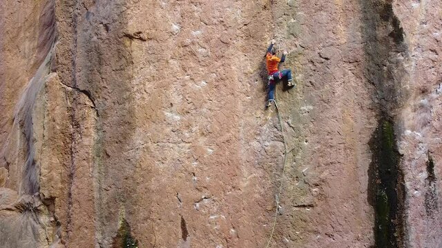 climber  climbing up a very flat wall (drone footage)