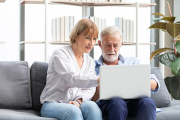 Fototapeta premium senior couple using laptop computer on sofa