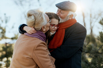 Grandma and grandpa enjoy with their sweet granddaughter on a sunny winter day.