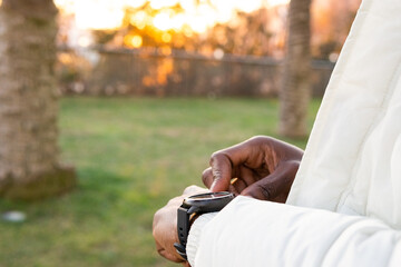 Faceless ethnic person with wristwatch in garden