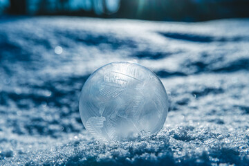 Fototapeta na wymiar frozen soap bubble in winter on snow. magic nature