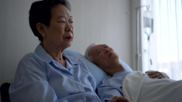 Asian senior admid sick in hospital bed wife sad and worry take care husband illness disease