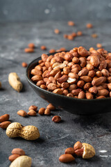Raw Peanuts in wooden bowl on natural gray rustic desk.