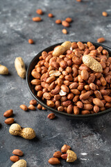 Raw Peanuts in wooden bowl on natural gray rustic desk.