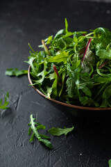 Obraz na płótnie Canvas Mix salad greens. Arugula, lettuce, spinach in black bowl