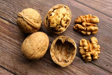 Walnuts on wooden background two whole one open and pair of walnut brain. photo top view 