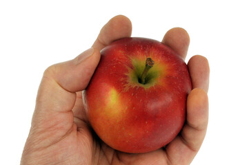 Pomme tenue en main en gros plan sur fond blanc