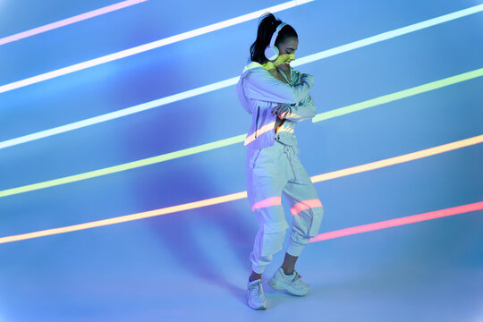 Young woman dancing hip hop in striped studio